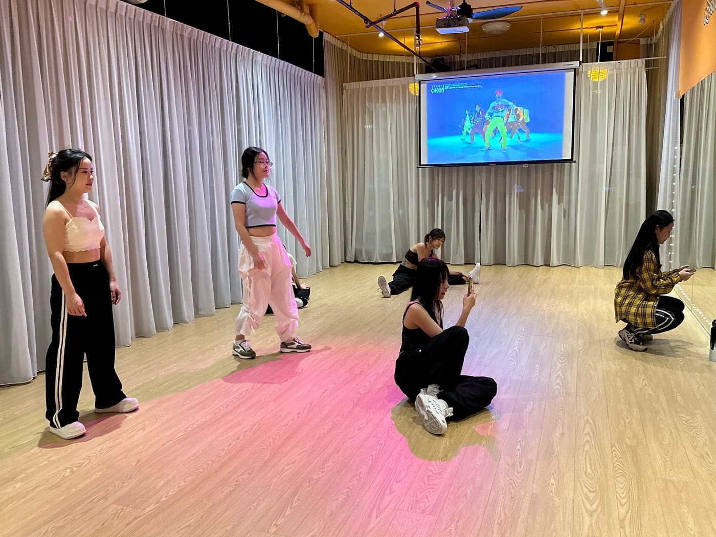 Dancers rehearsing a routine with the screen behind them